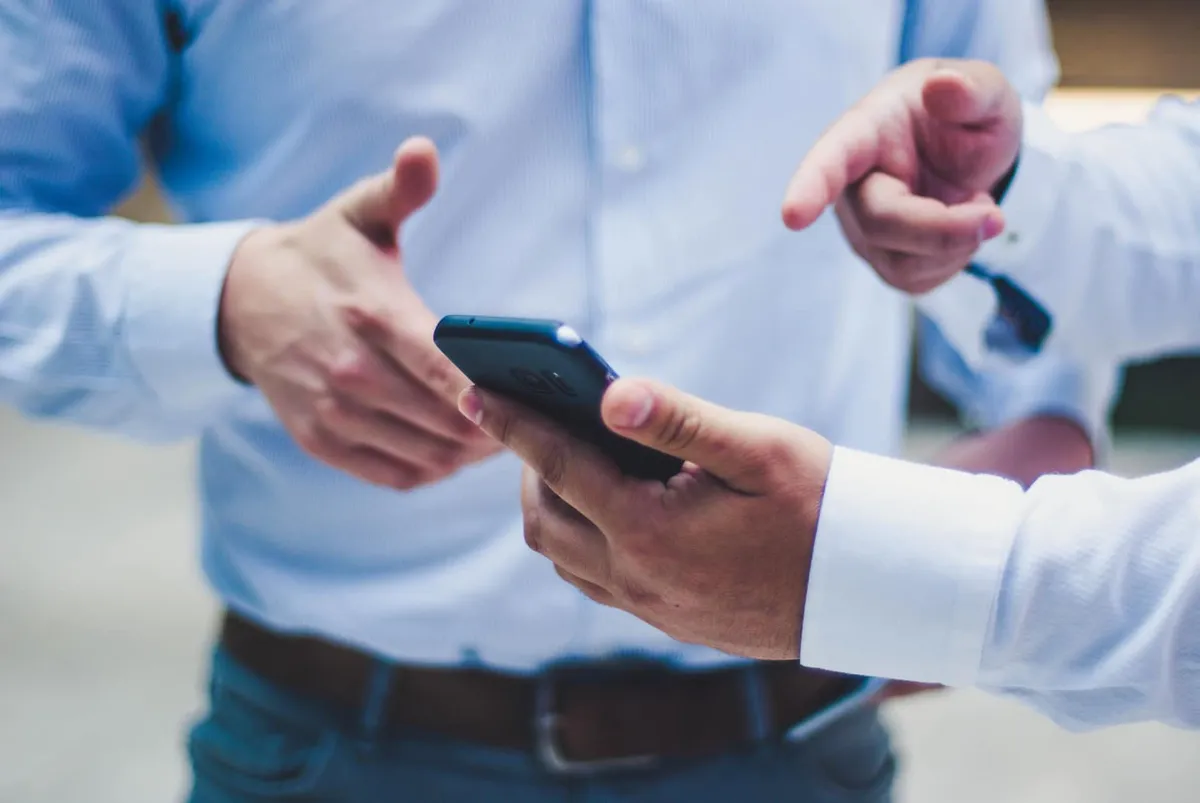 Zwei Personen besprechen einen Termin am Smartphone