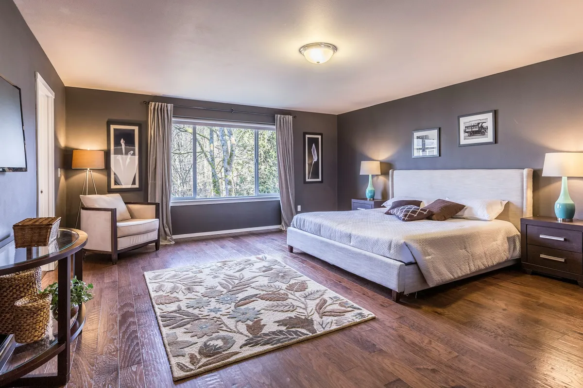 Schlafzimmer mit gemachtem Bett und Teppich